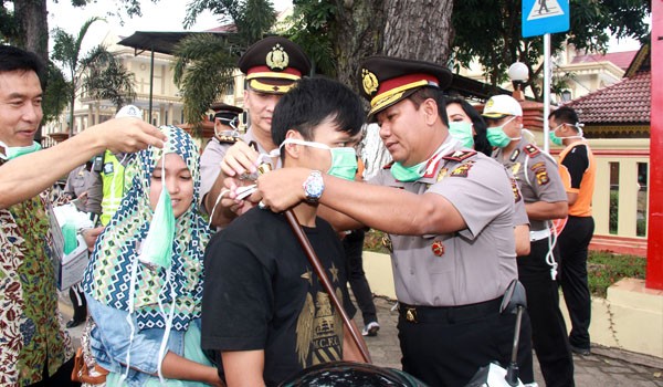 Kapolda Jambi Brigjen Pol Drs Bambang Sudarisman memasangkan masker kepada penmgendara di depan Mapolda Jambi. F/M RIDWAN/JAMBIUPDATE.COM