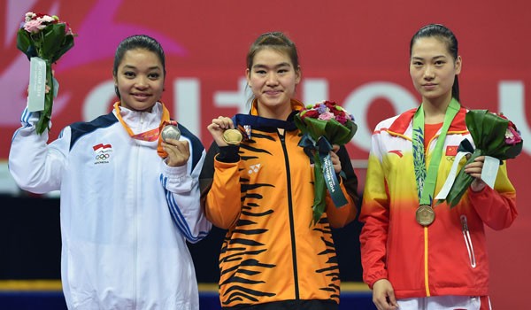 Atlet wushu Indonesia, Juwita Niza Wasni (kiri), Tai Cheau Xuen dan Hong Wei, usai pengalungan medali. Foto: Bay Ismoyo/AFP
