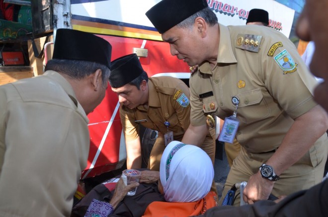 Walikota saat menolong salah satu jemaah haji lansia naik bus.