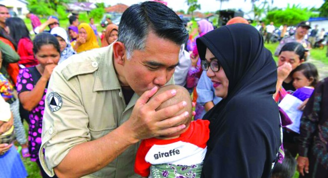 Walikota Jambi mencium seorang anak tanda kasih sayang kepada warganya yang terkena musibah banjir.