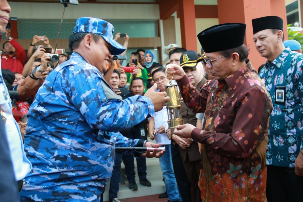 Plt Gubernur Jambi Fachrori Umar, menerima langsung Api Obor Asian Games 2018, yang diberikan oleh Komandan Pangkalan TNI AU Sri Mulyono Herlambang, Kolonel Pnb Heri Sutrisno. 