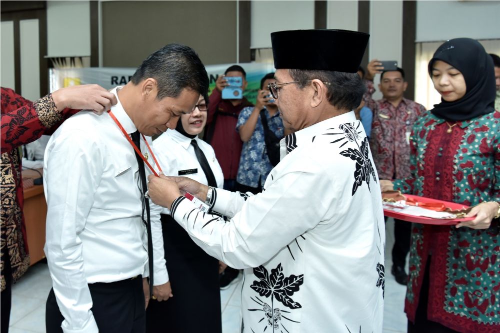 Plt Gubernur Jambi Fachrori Umar memasang kartu tanda peserta diklat kepada salah satu peserta Diklat Pim III Angkatan XI