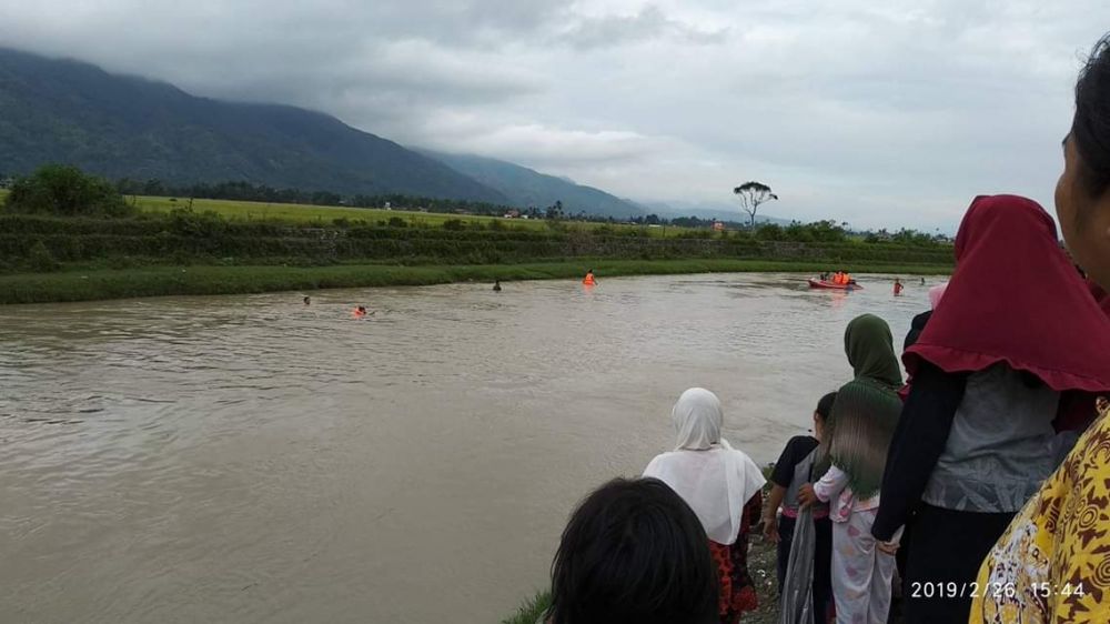 Warga Menyaksikan Proses Pencarian Seorang Bocah yang diduga Tenggelam