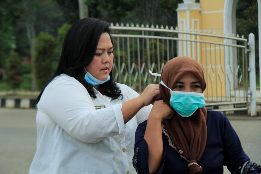 Kadinkes Tebo, Dr Riana saat memasang masker kepada salah seorang pengendara motor di Komplek perkantoran Bupati Tebo