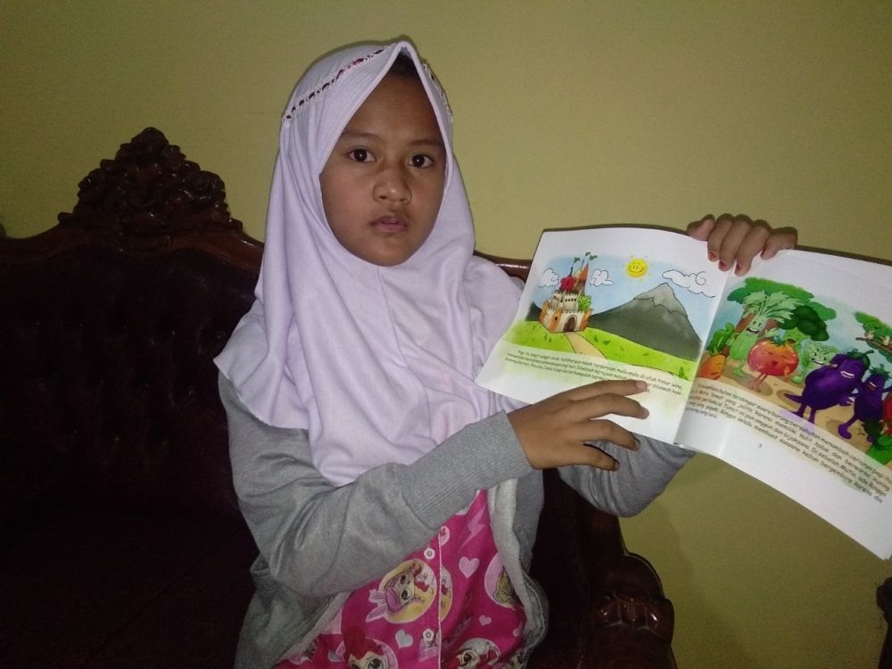 Alfathu Sabina Pradaka menunjukkan buku yang dibacanya