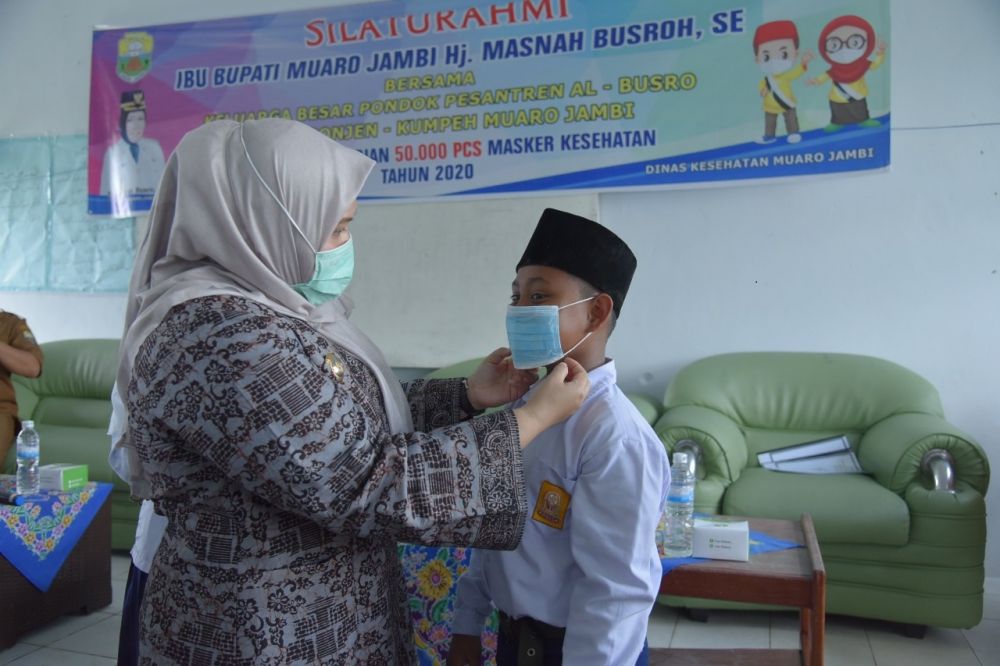 Bupati memakaikan masker ke salah seorang siswa