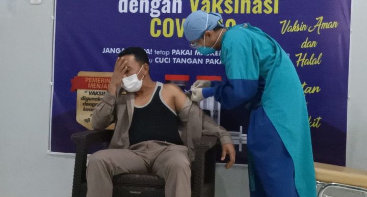 Ketua DPRD Tebo, Mazlan menutup matanya saat disuntik Vaksin