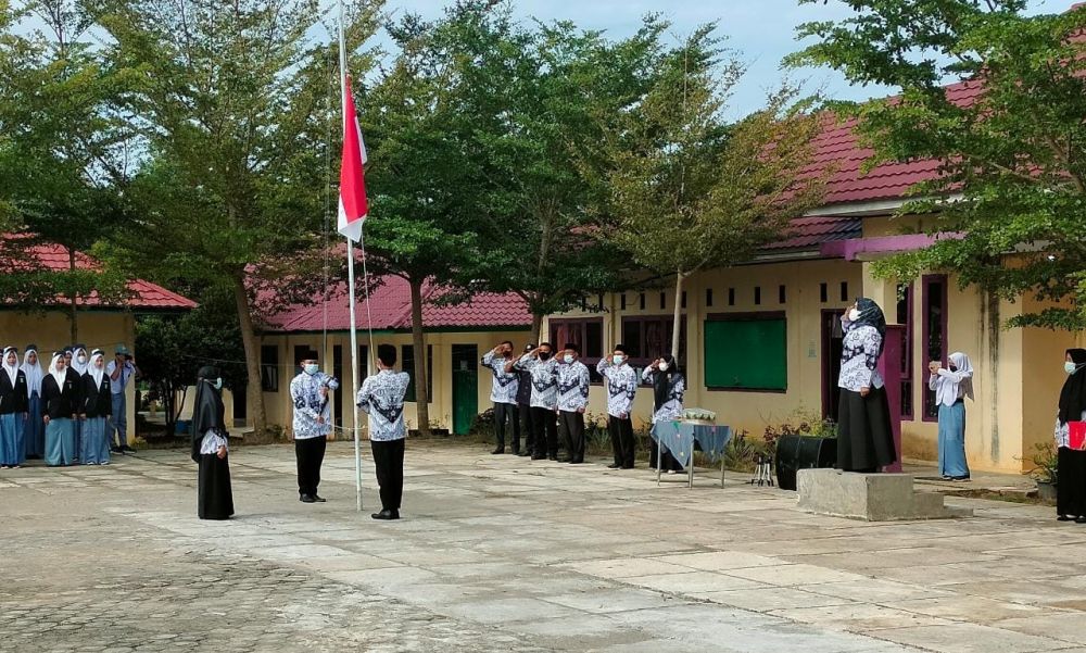 Pengibaran bendera merah putih dengan petugas upacara dilakukan oleh guru dan tenaga kependidikan