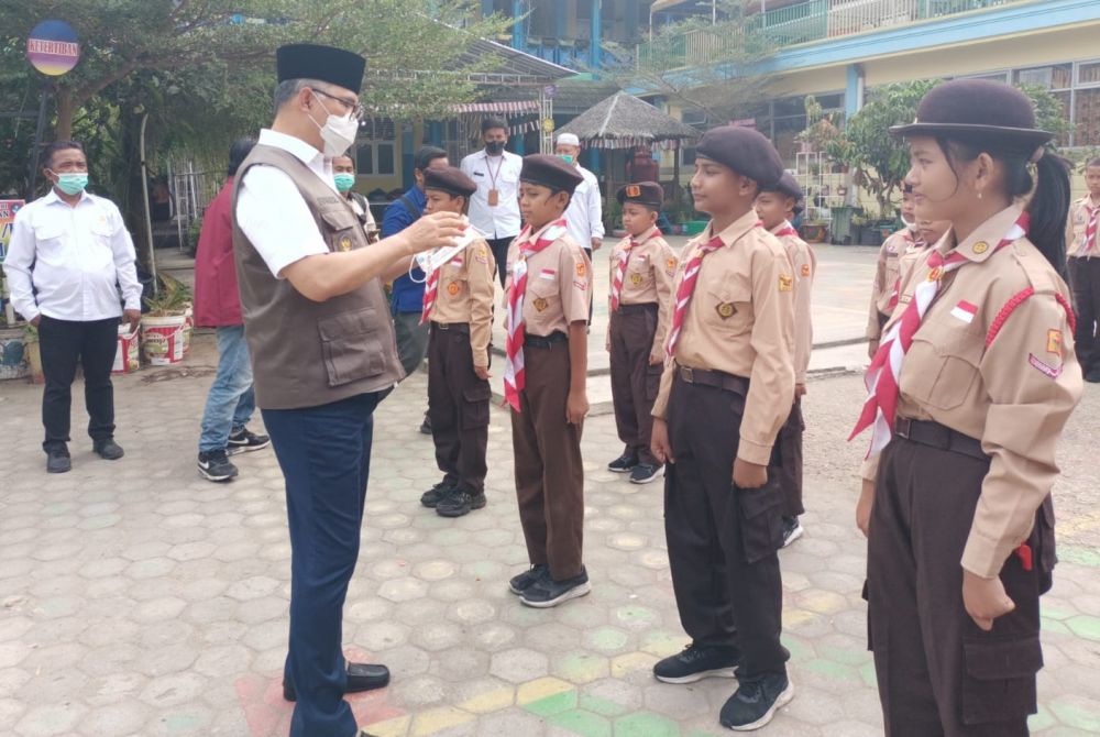 Wali Kota Jambi Syarif Fasha memakaikan masker kepada salah seorang siswa sebagai upaya menjaga kesehatan dari dampak kabut asap, Rabu (6/9/2023)