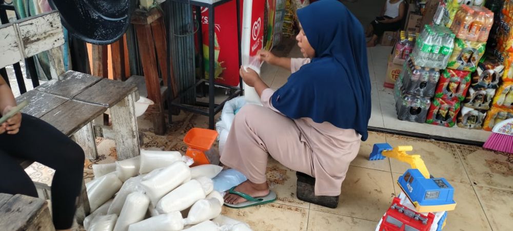 Salah seorang pedagang di Tebo sedang mengemas gula pasir eceran