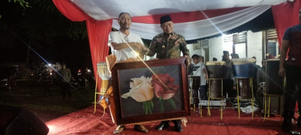 Syahrial menyerahkan lukisan mawarnya kepada PJ Bupati Tebo sebagai cenderamata