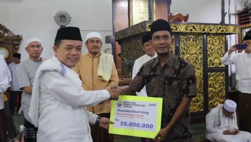 Gubernur Jambi Al Haris saat menyerahkan bantuan dana hibah ke salah satu pengurus masjid di Kabupaten Bungo, Rabu (20/3).