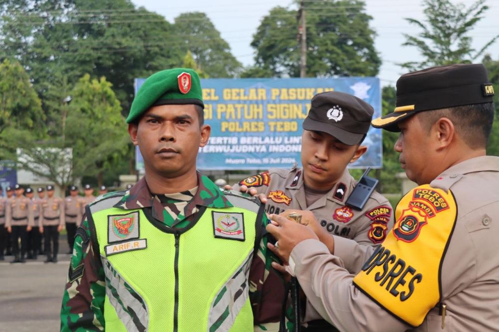 Kapolres Tebo memasangkan pita kepada personel TNI yang ikut membantu pelaksanaan operasi Patuh 2024