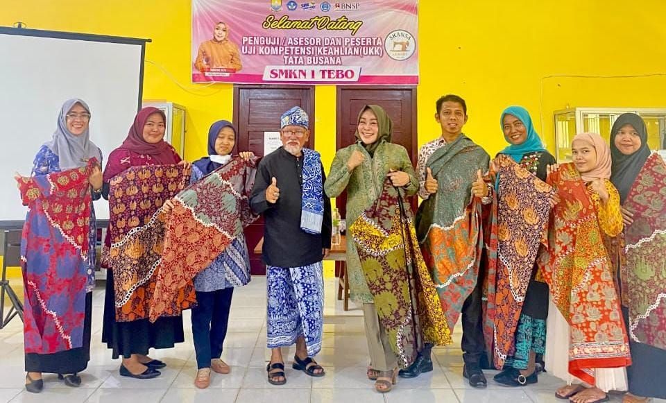 Kepala SMKN 1 Tebo, Ramayani, M.Pd didampingi para guru bersama pakar batik Jambi  Zainul Bahri dan dosen pendamping Dr. Ilham Zamil dari UNP memperlihatkan batik Tebo karya Siswanya.jpeg