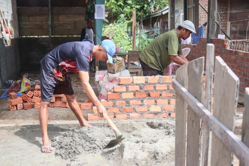 Hendri pemilik rumah ikut membantu TNI dalam merehab rumahnya.jpg