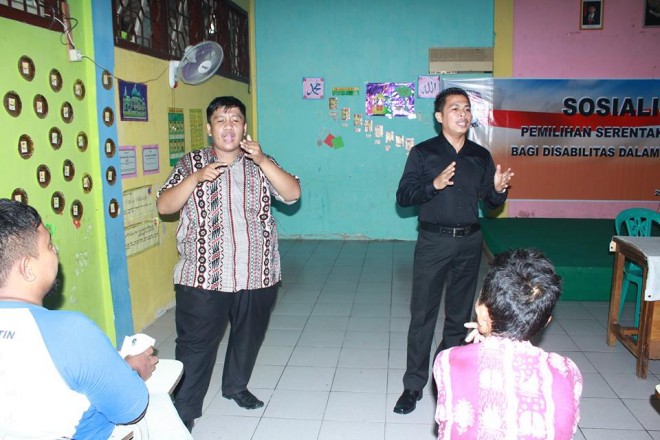 Desy Arianto bersama pemandu penyandang disabilitas saat melakukan sosialisasi pilkada.