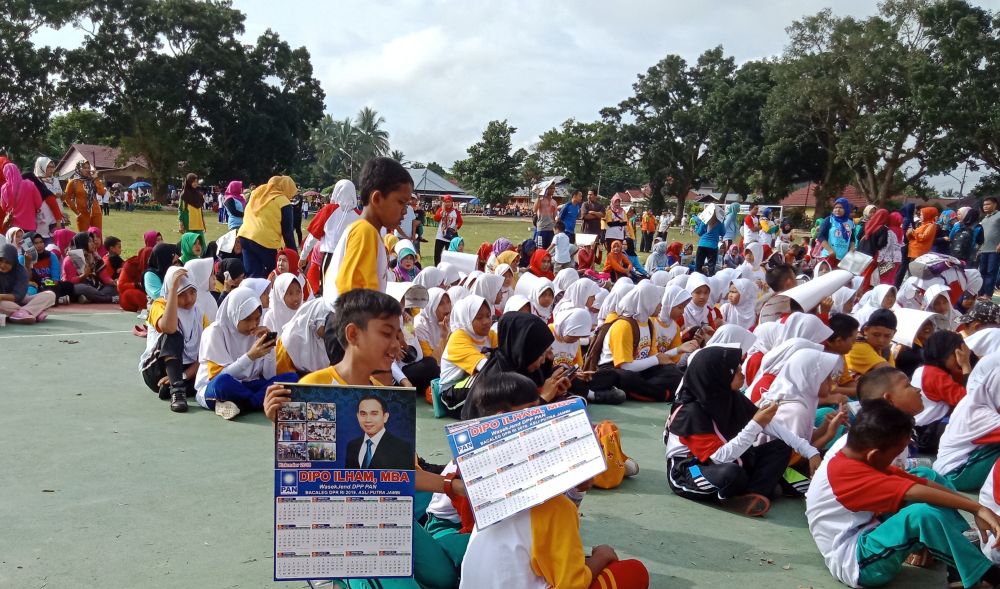 Salah seorang pelajar yang mendapat pembagian kalender Dipo Ilham di lapangan Basamo Sarolangun, pasca mengikuti senam sehat, Jumat (16/3), pagi 