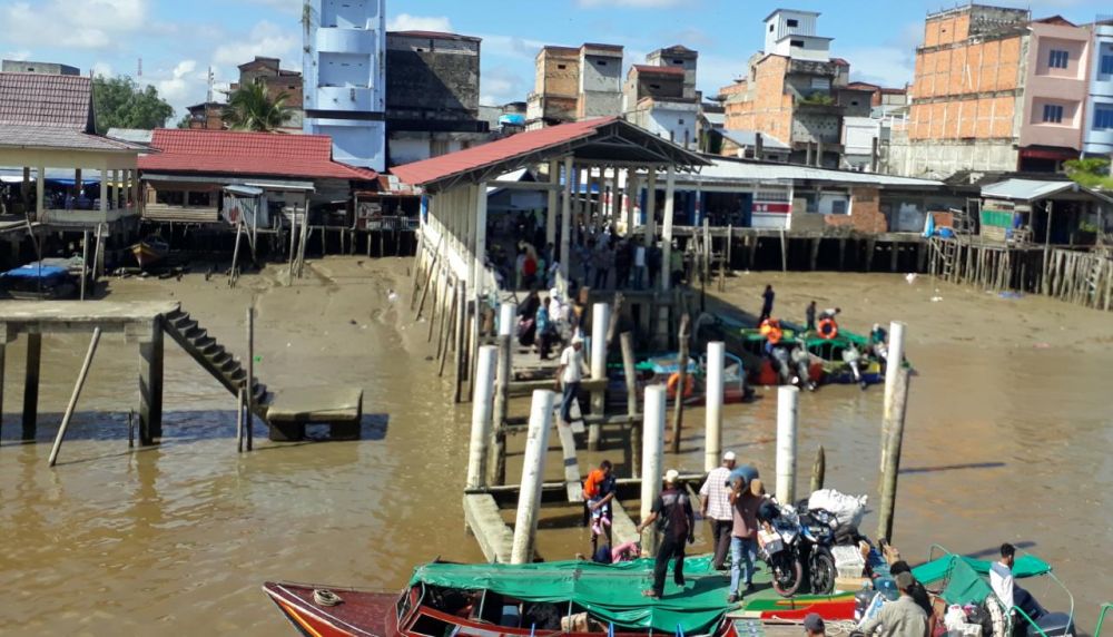 Tampak penumpang speed boat melewati sehelai papan menuju Kapal.