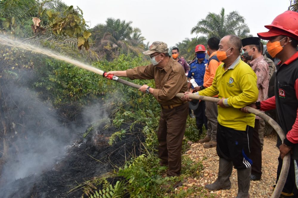 Terlihat H Cek Endra memadamkan api di di lokasi kebakaran lahan masyarakat desa Sungai Abang