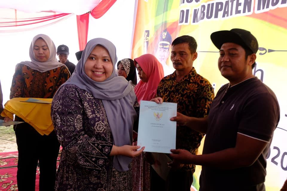Bupati menyerahkan sertifikat tanah ke warga.
