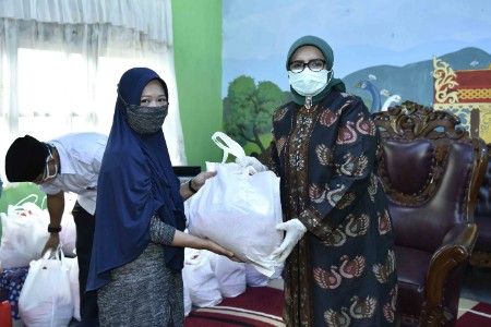Ketua TP PKK Provinsi Jambi Hj.Rahima Fachrori menyerahkan paket sembako untuk para guru, tenaga kependidikan dan masyarakat sekitar yang terdampak covid-19 