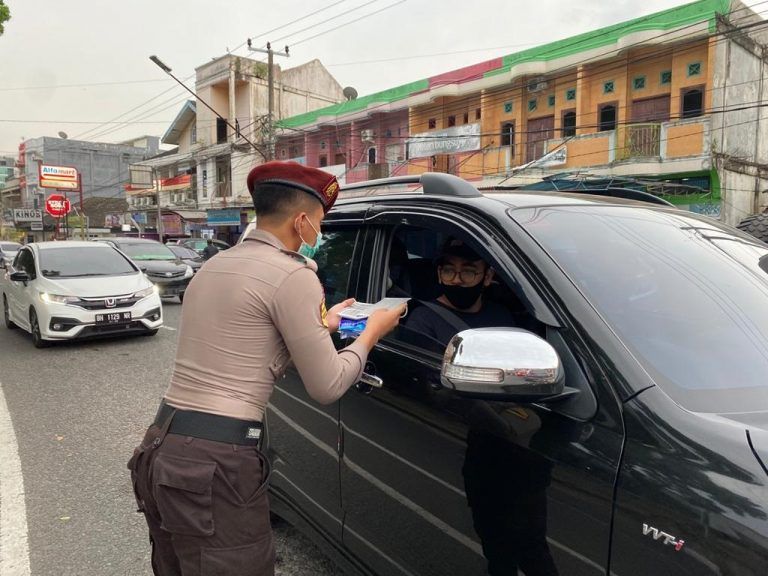 Taruna Akademi Kepolisian (Akpol) asal Jambi saat membagi masker ke pengendara. 