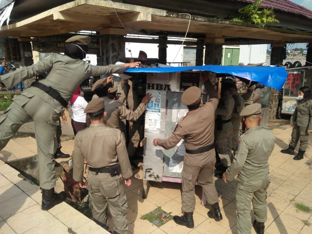 Pol pp mengangkut gerobak PKL di Ancol yang ditingal  pemiliknya untuk di tertibkan.