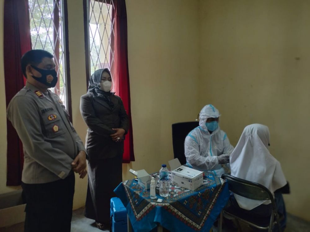 Kepala SMKN 5 Ramayani M.PD mendampingi Kapolsek Rimbo Ilir AKP Ibrahim mengecek pelaksanaan vaksinasi covid 19