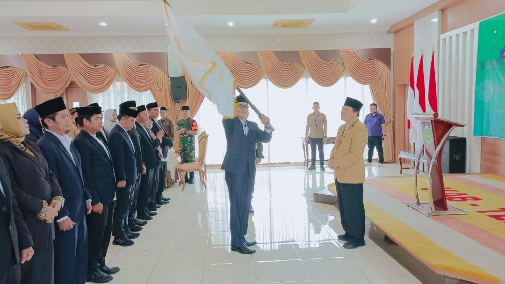 Nurhuda saat mengibarkan bendera panji ICMI Orda Tebo yang diterimanya