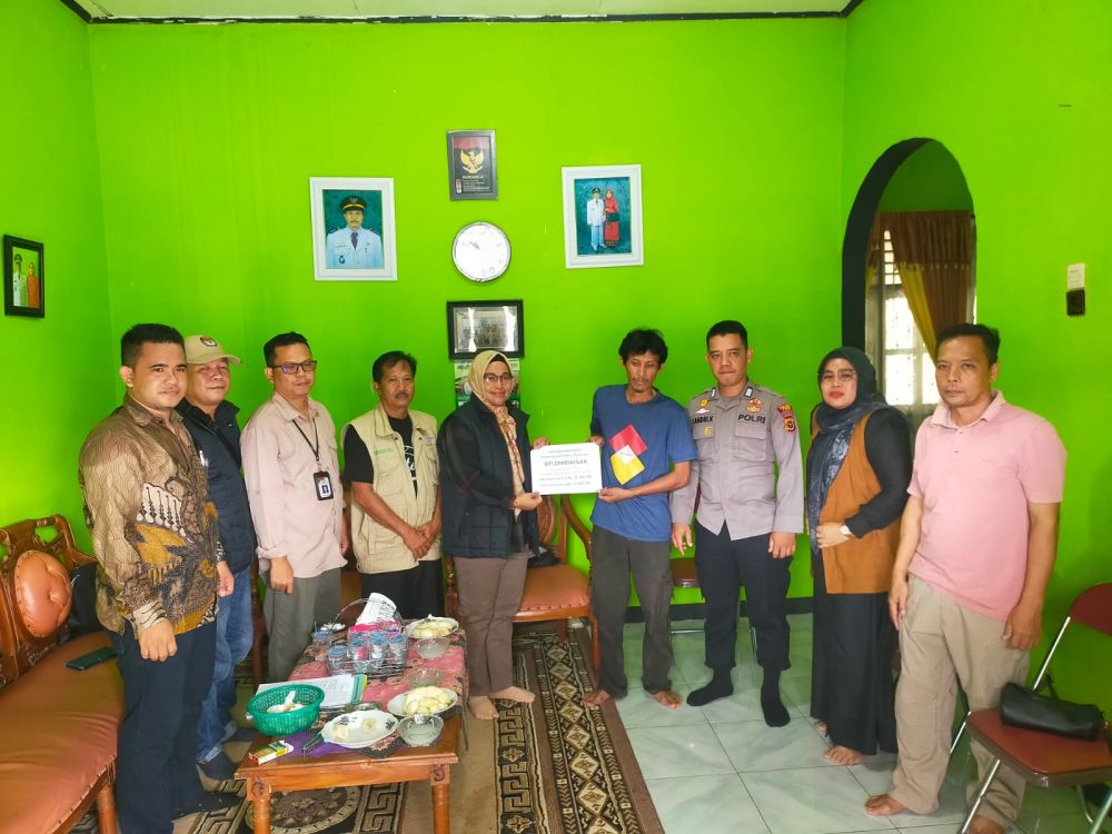 Ketua KPU Kabupaten Tebo didampingi Sekretaris menyerahkan santunan untuk KPPS yang meninggal dunia