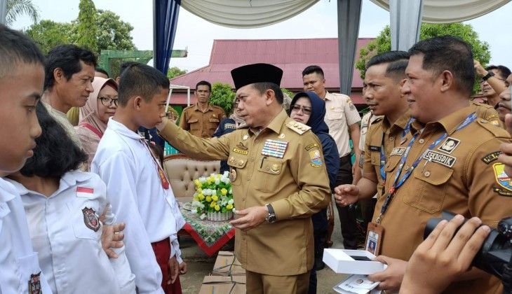 Gubernur Jambi Al Haris saat menyerahkan bantuan pendidikan kepada siswa tak mampu 